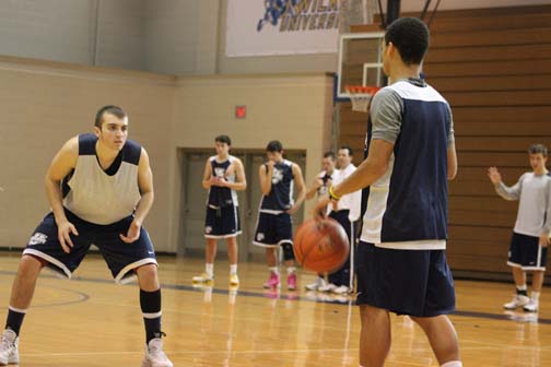 Guard Devin Dunn, at left, gets set on defense during a recent practice session for the Colonels at the Marts Center.  The 6-2 guard from Staten Island will be one of the team captains for the 2013-14 season.