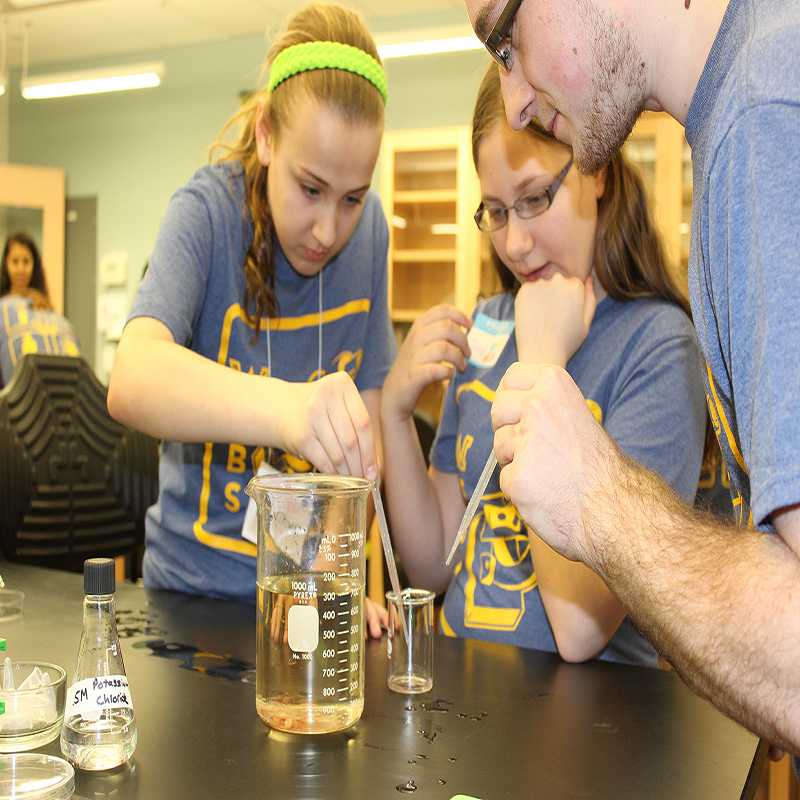 Matthew Yatison helps two sixth grade students from Holy Rosary, Duryea, as they remove the eggs of a sea urchent for closer examination. 