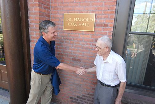 Dr. Cox and President Leahy shake hands at the dedication of Cox Hall.