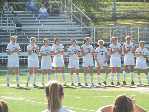 The women’s soccer team cheers each other on as the starting lineup is announced at a home game.