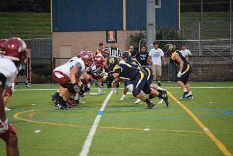 Members of Wilkes' offensive line look to gain ground against the Muhlenberg defenders.