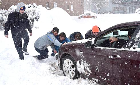 Wilkes Students Cody Morcom, Dylan Fox, Teddy Marines and Corey Cowitch assist a Wilkes-Barre resident whose car is stuck on S. Main St. The group spent their snow day driving around and helping perilled residents after their original plans to go sledding were cancelled.