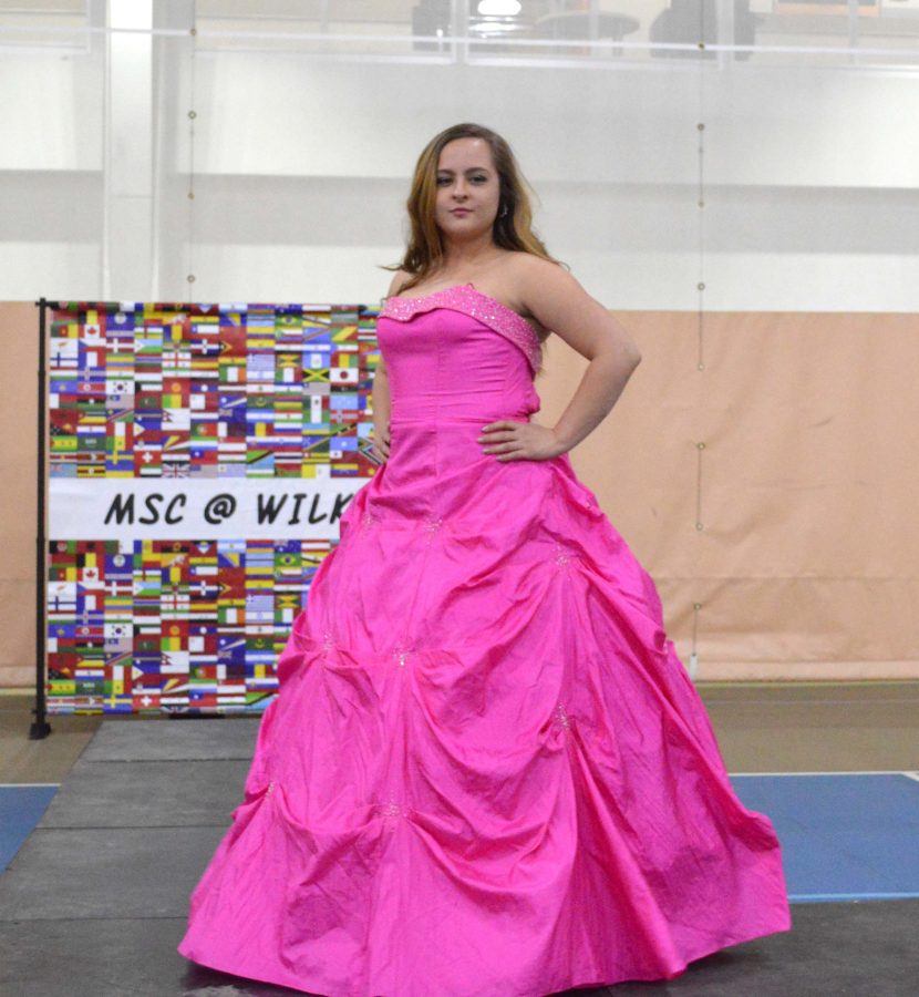 Freshman Suzi Cook shows off her poofy gown. Cook volunteered because she “loves prom.” Cook said that the volunteer work did not feel like community service because the students were “having fun.” High school students who attended the event and liked a dress they saw on the runway were able to bring one home at no cost.
