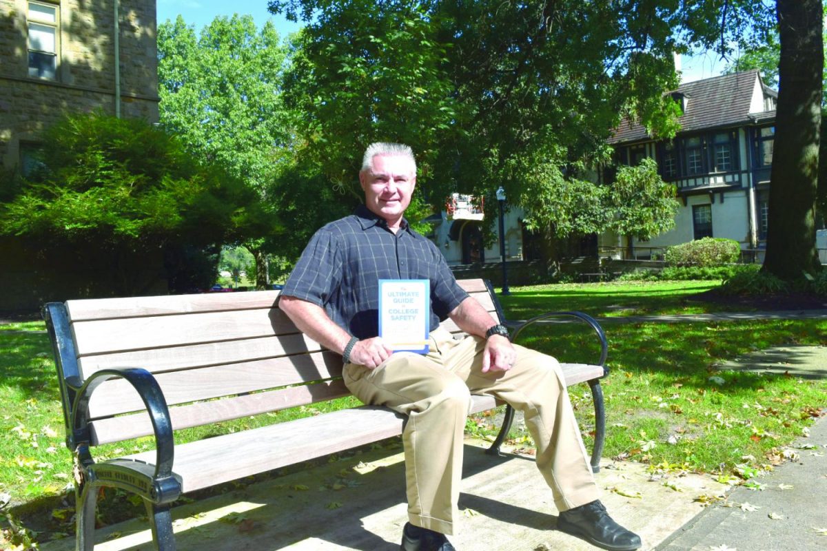 Public safety officer Peter J. Canavan stands with his newly published book on college campus safety.