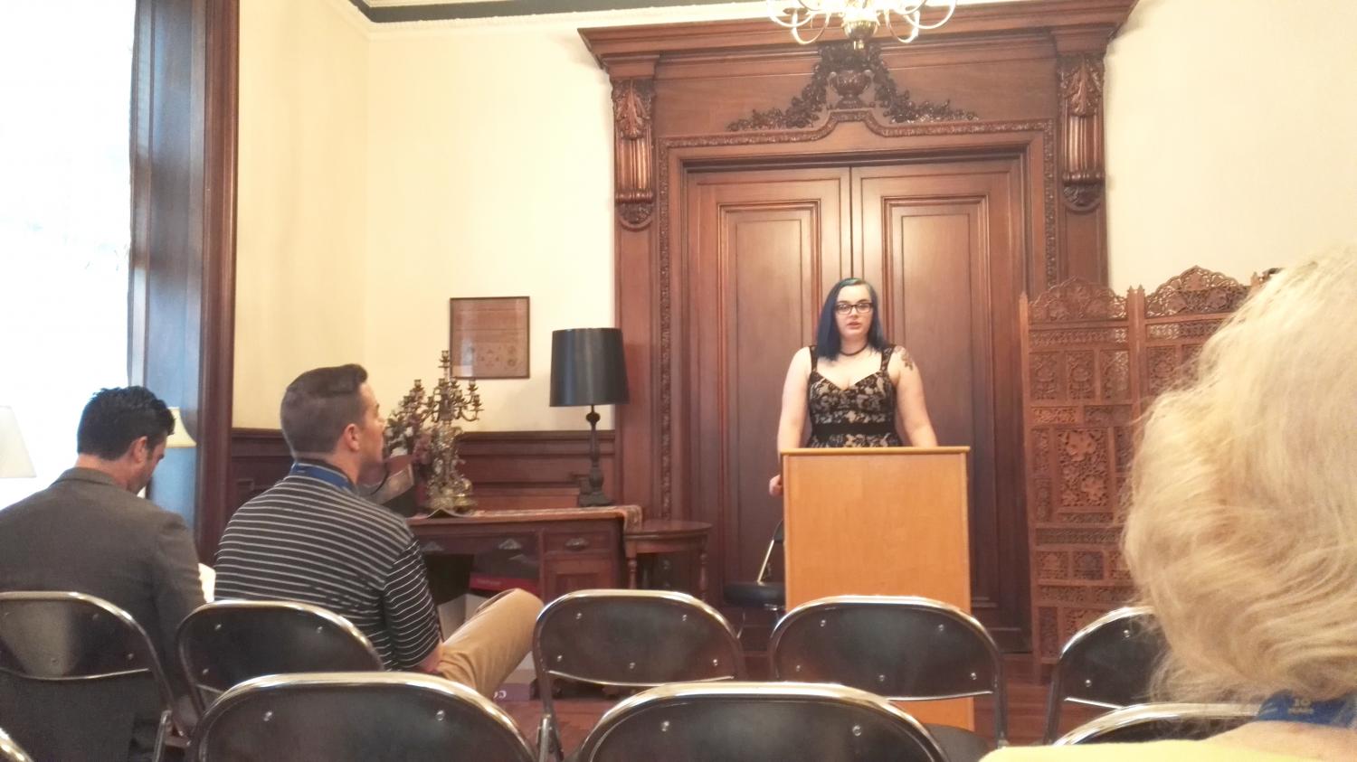 Elyse Guziewicz, the executive editor of the magazine, stands at the podium to introduce each speaker at the gathering.