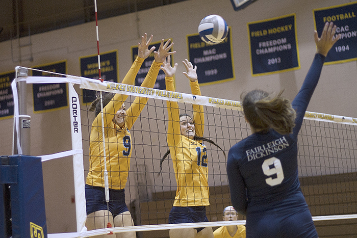 Senior Jamey Mikovich (9) and sophomore Michele Natale (12) attempt to block an FDU-Florham attack from junior Lauren Harris (9).