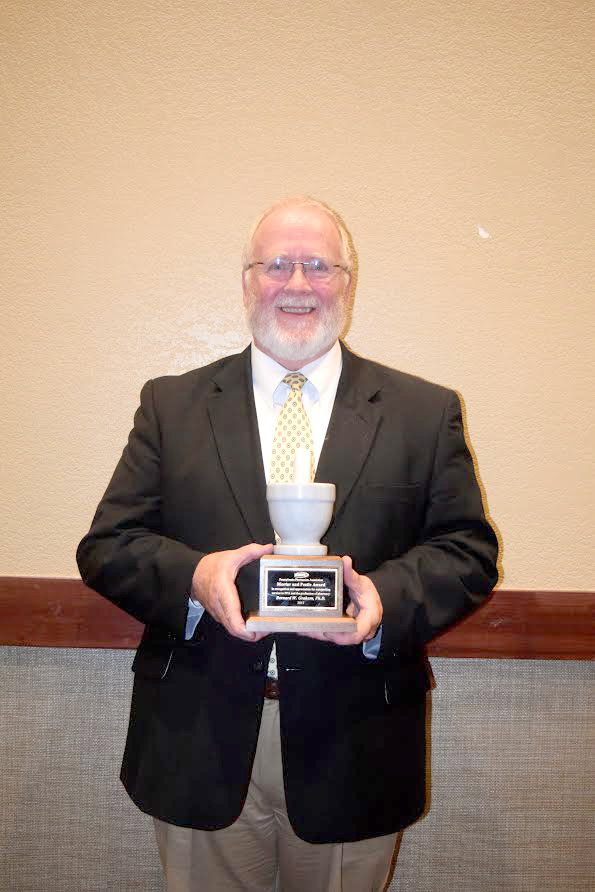 Dr. Bernard Graham holding his Mortar and Pestle Award, awarded to him at the 2017 Pennsylvania Pharmacists Association. 