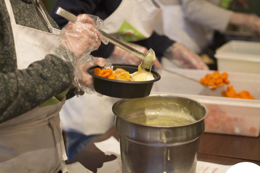 Volunteers package meals for the Dinners for Kids program