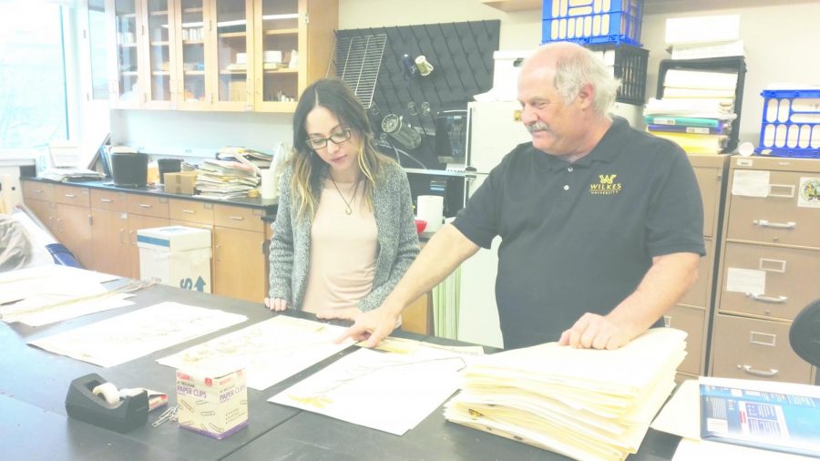 Laura Solomon, senior biology major, looking at the corydalis plant with Dr. Kenneth Klemow in the Herbarium. 