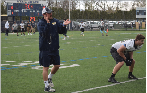 Coach Tom Elder giving instruction during a rainy spring practice.