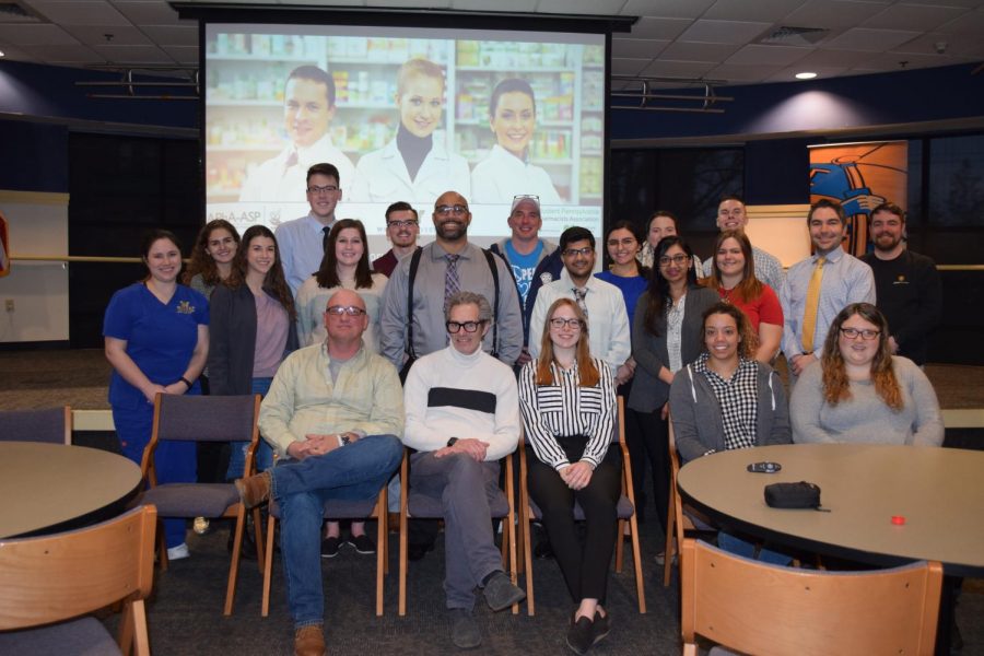 Devin Reaves poses with Wilkes Pharmacy and Nursing students, faculty and community professionals who attended his talk about harm reduction.