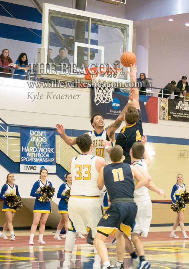 Senior Tommy Bowen secures the basket under the net for Wilkes.