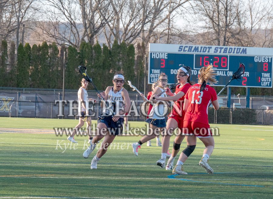 Freshman Domenica Lerch dances past a pair of Monarchs on her way towards to King’s net.