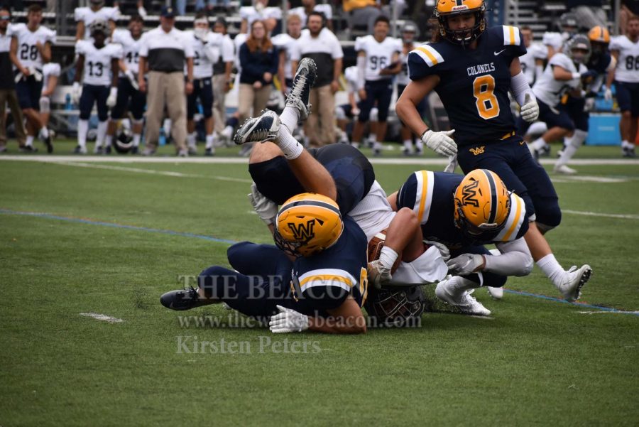 Senior captain Bud Moyer (right) assists on a tackle in the Colonels’ home opener against Lebanon Valley on Sept. 14. 
