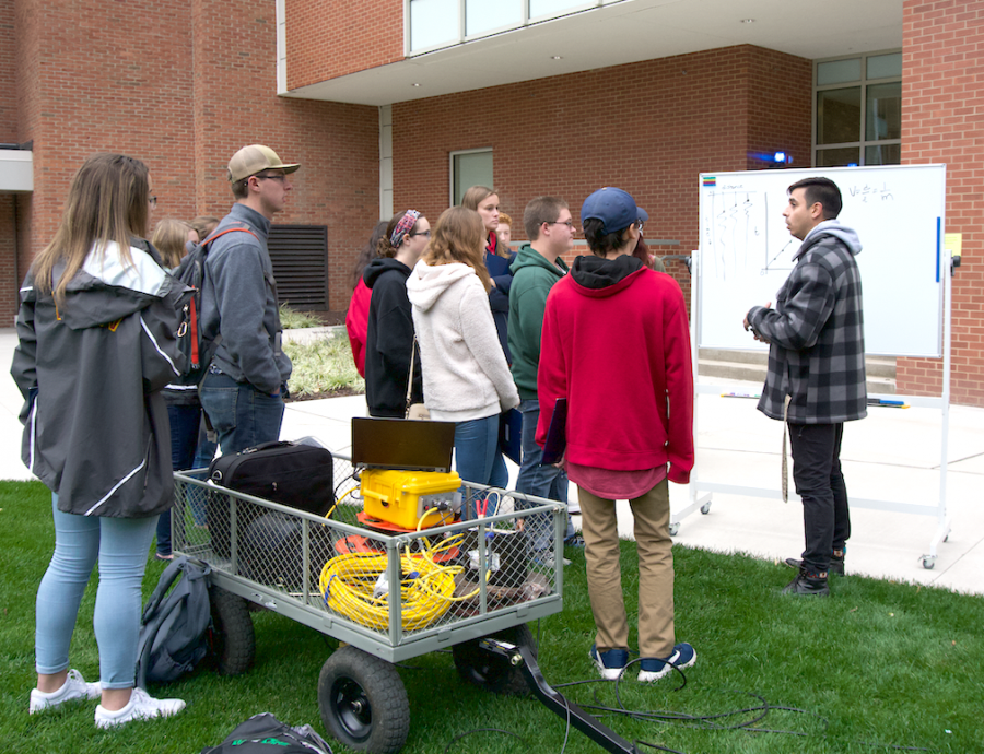 Dr. Bobby Karimi, assistant professor of environmental engineering and Earth sciences, explains to visiting students his station on gravity anomalies.