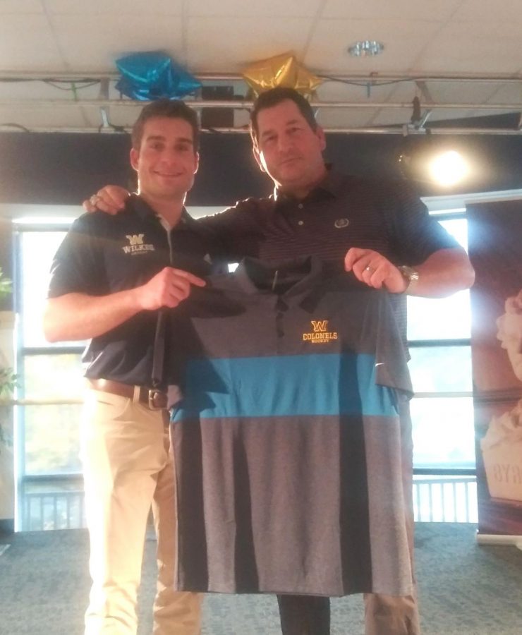 Tyler Hynes, Men’s Ice Hockey Head Coach, presents Bonvie with a Wilkes hockey shirt.