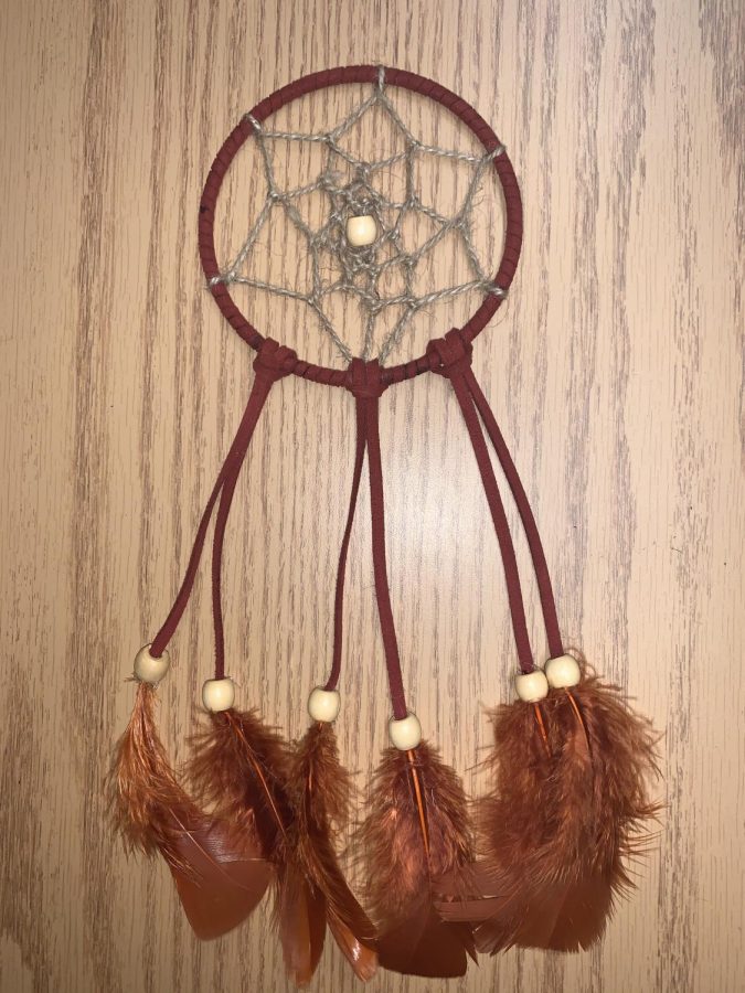Step 6: Add feathers and beads to complete the dreamcatcher.