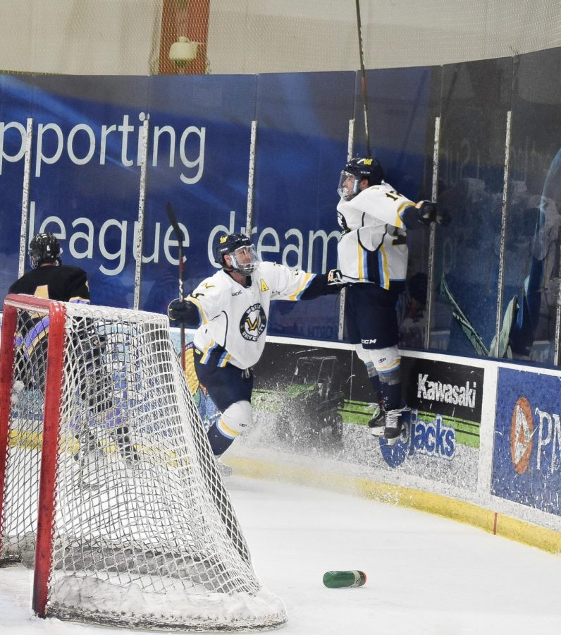 Tyler Barrow (right) jumps into the air in celebration following his overtime goal, as Devon Schell (left) is the first player to greet him.