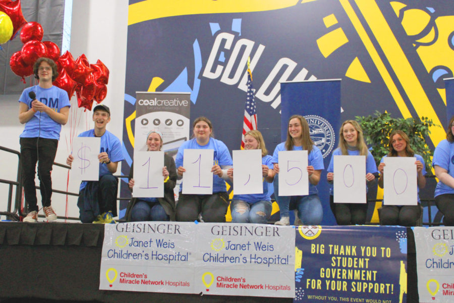 As of Saturday, March 26, Dance Marathon raised more than $11,500 for the Geisinger Janet Weis Children’s Hospital through the Children’s Miracle Network, as announced by Donald Ballou, executive director (far left). From left to right, holding the signs: Kaleb Hanson-Richart, special events chair; Cassidy Taylor, external director; AJ Rubino, fundraising chair; Maddy Kinard, internal director; Ariel Reed, finance director; Lauren Gardner, volunteer; Ariano Como, public relations chair. Donations are still being accepted until April 4.