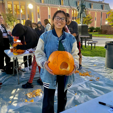 Veronica Cordero, a first-year criminology major, shows off the first pumpkin cuts. 