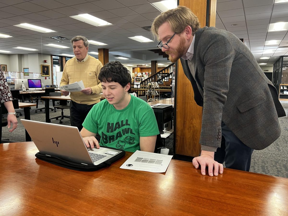 Aiden Hermon, first year pharmacy major, working to transcribe a document with Dr. Jonathan Kuiken.