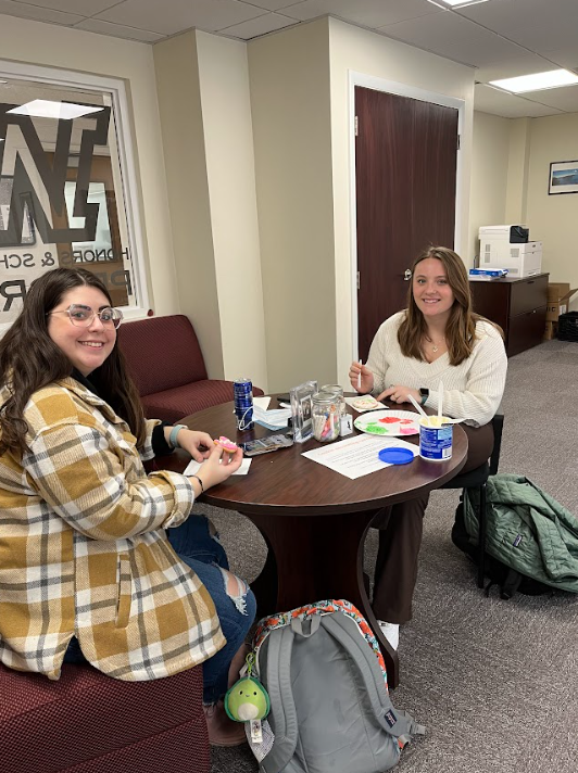 Liz Cherinka (left), junior P1 pharmacy major, and Ally Warnz (right) sophomore pharmacy majors take a break from decorating to pose for a photo.