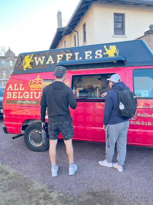 Mason Vonk (left) freshman mechanical engineering student and John Barett
(right) junior marketing student ordering waffles from the All Belgium truck.