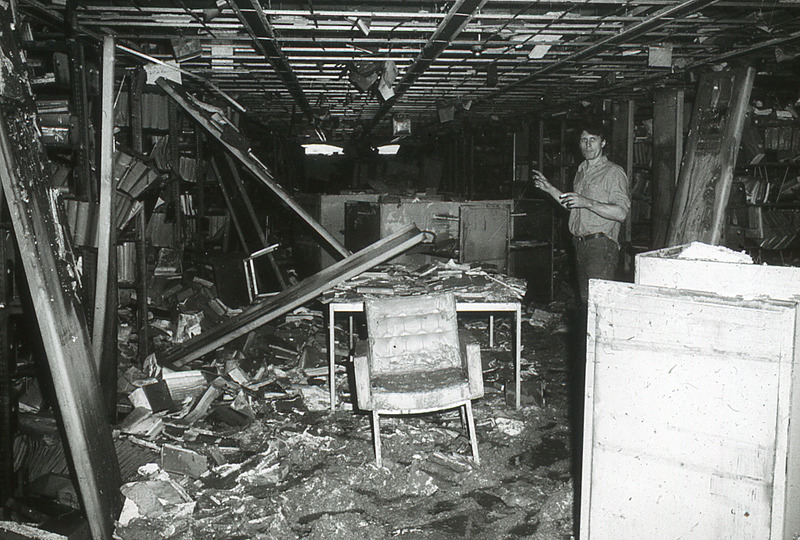 Within the basement of the Eugene S. Farley Library, an unindentified, presumed staff member, assesses the destroyed bookshelves and materials.