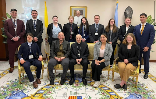 Back Left to Back Right: Christian Blomquist, Colin Post, Morgan Steiner, Connor Frey, Sean Renz, Damien Chmielewski, Julie Schwartz, Emma Stout and Eduardo Abrego Camano.Front Left to Front 
Right: Vassiliki Gkroutski, Dr. Andy Miller, Archbishop Gabrielle Caccia, Marytere Quintana-Avila and Emma Guzdek.