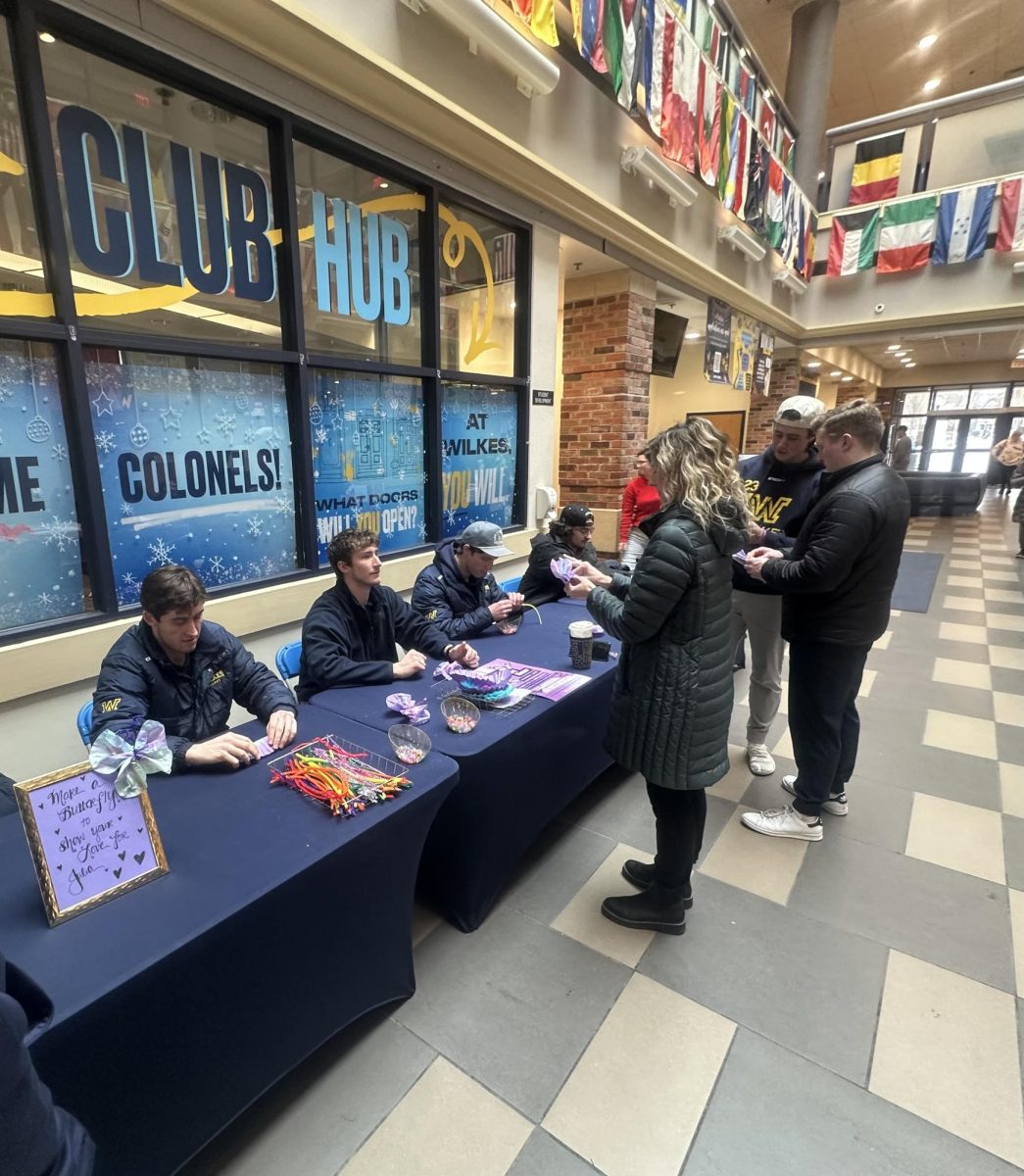 Wilkes men's hockey team members invite students, faculty and staff to make butterflies.