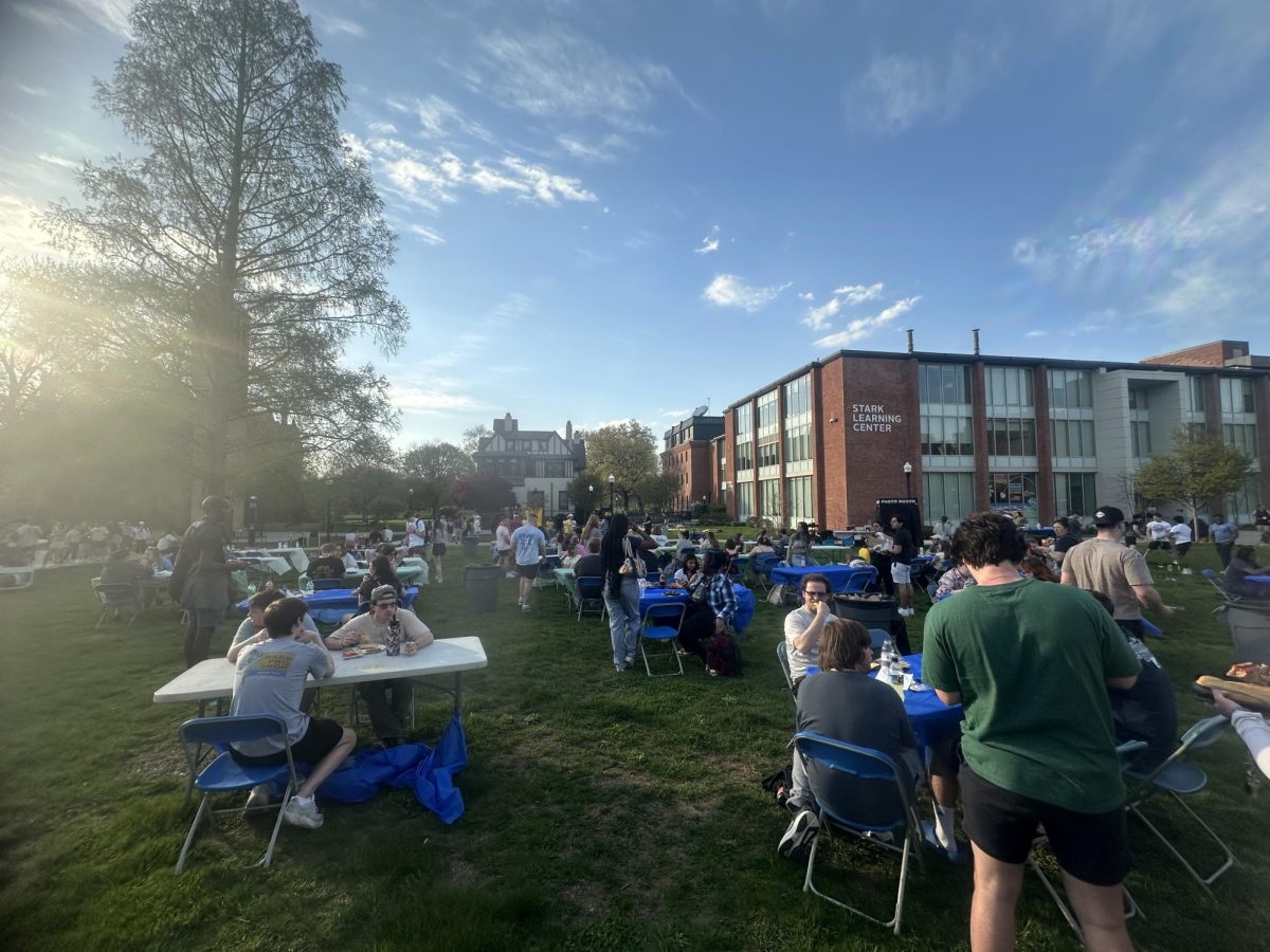 Students sit at tables on the greenway, enjoying the warm weather for the County Fair event on April 24.