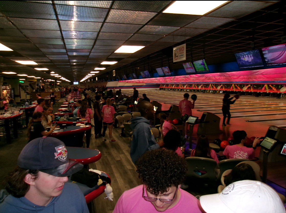Students gather to eat pizza and bowl with friends.