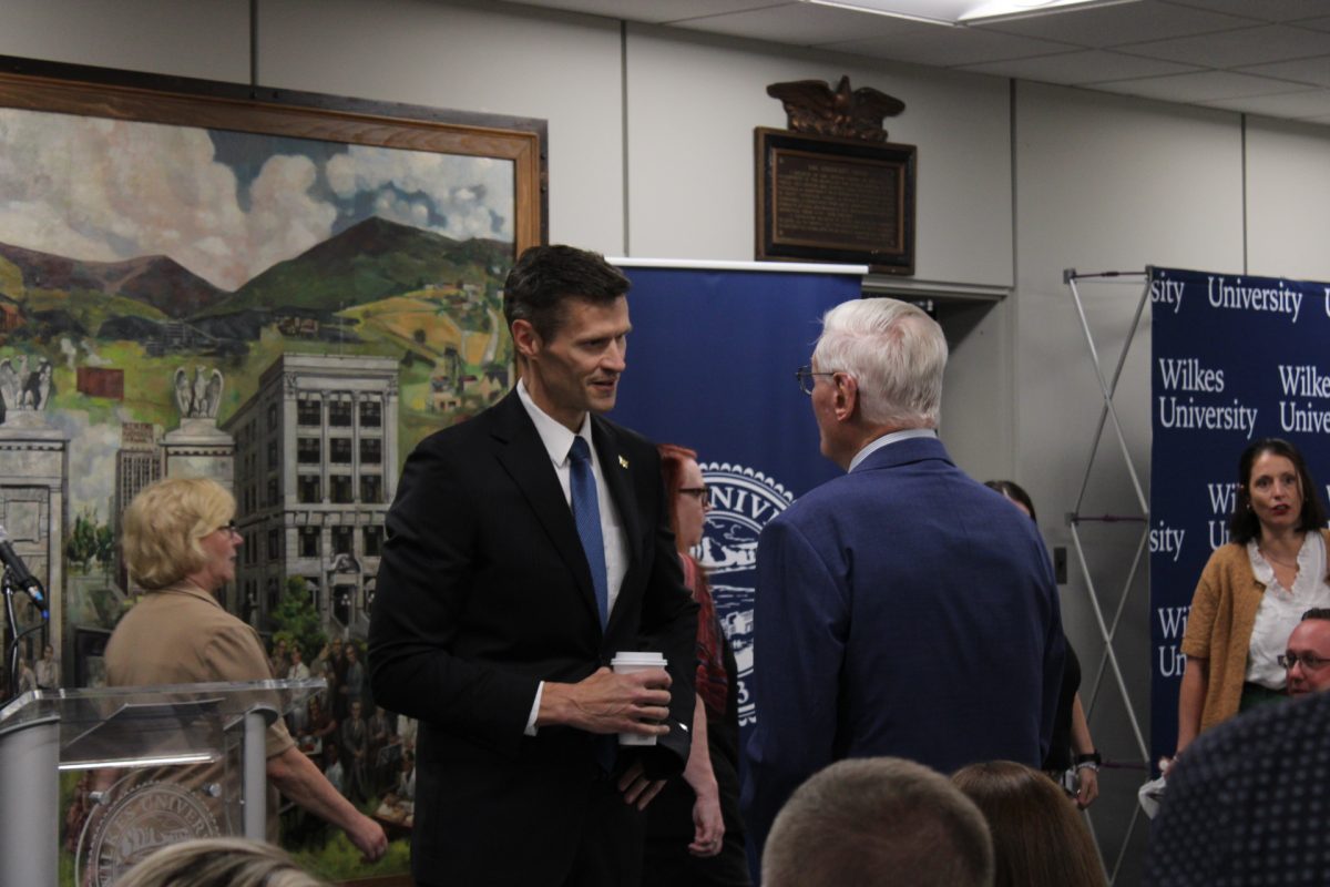 Dr. James Cousins, Wilkes University's 8th president, speaks with William Hanbury, class of '72.